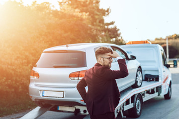 Elegant middle age business man using towing service for help car accident on the road. Roadside...