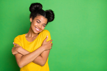 Just me myself and I. Photo of pretty dark skin lady holding herself in close hugs wear casual yellow t-shirt and red pants isolated green background - obrazy, fototapety, plakaty