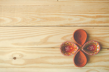 Happy Diwali - Clay Diya lamps lit during Dipavali, Hindu festival of lights celebration.oil lamp diya on wooden background