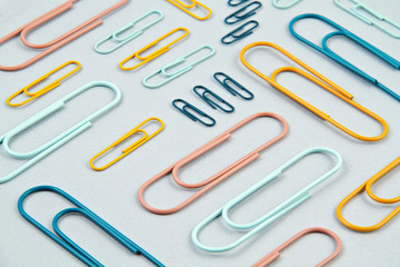 Top view of Colorful paper clips over the  pastel background