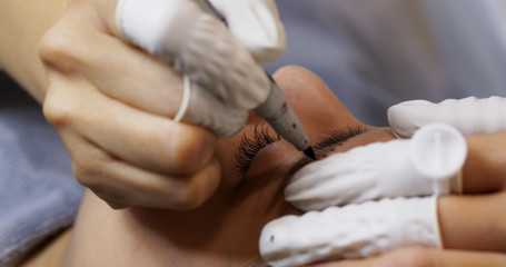 Woman having microblading eyebrows in a beauty salon