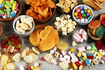 Foto op Aluminium Salty snacks. Pretzels, chips, crackers and candy sweets on table © beats_