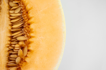 Fresh sweet orange melon on the white plate as a background with a selective focusing. Useful and vitamin-rich food. Vegeterian.