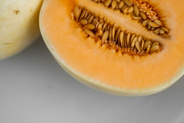 Fresh sweet orange melon on the white plate as a background with a selective focusing. Useful and vitamin-rich food. Vegeterian.