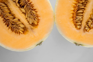 Fresh sweet orange melon on the white plate as a background with a selective focusing. Useful and vitamin-rich food. Vegeterian.