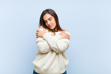 young pretty woman feeling in love, smiling, cuddling and hugging self, staying single, being...