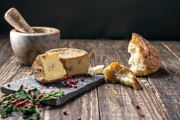 Artesian Cheese and a homemade souer dough bread on wooden background.