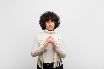 young pretty afro woman scheming and conspiring, thinking devious tricks and cheats, cunning and...