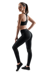 Fototapeta na wymiar Brunette woman in black leggings, top and sneakers is posing isolated on white. Fitness, gym, healthy lifestyle concept. Full length.