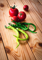 tomatoes and peppers on wooden table