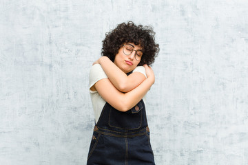young pretty afro woman feeling in love, smiling, cuddling and hugging self, staying single, being...