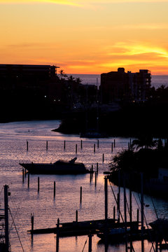 Silhouette of a yacht moored in a marina at sunset