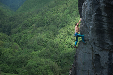 Muscular rock climber climbing