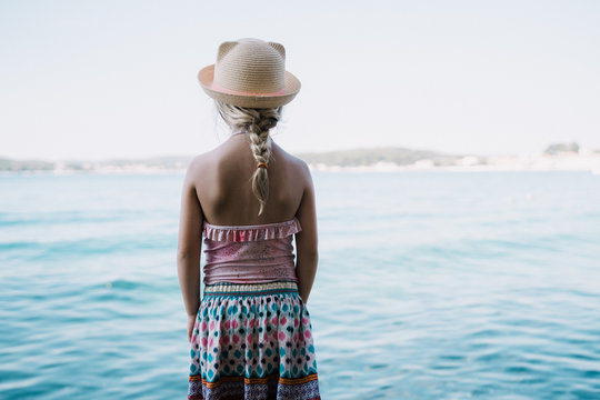 Little girl looking across the ocean