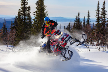 In deep snowdrift snowmobile rider make fast turn. Riding with fun in deep snow powder during backcountry tour. Extreme sport adventure, outdoor activity during winter holiday on ski mountain resort