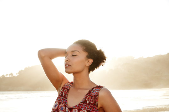 Portrait of African American woman backlit by the sun at the beach