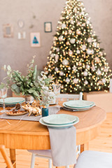 Christmas table with dish on the background of christmas tree
