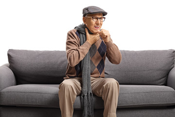 Elderly man sitting on a sofa and cauging