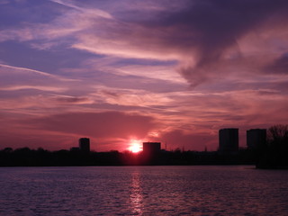 Naklejka premium sunset over city with buildings silhouette