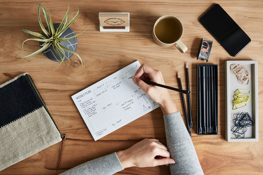 Overhead shot of a small business owner writing in weekly planner