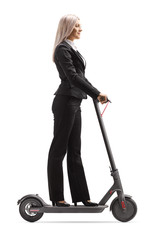 Woman in formal clothes riding an electric scooter to work