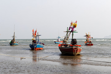 Fishing boats are waiting for water at the beach