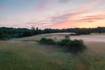 Fototapeta na wymiar Magnificent sunset and mist spreading across the field, Leningrad region, Russia