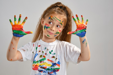 Little girl in white t-shirt is posing standing isolated on white and gesticulating with her...