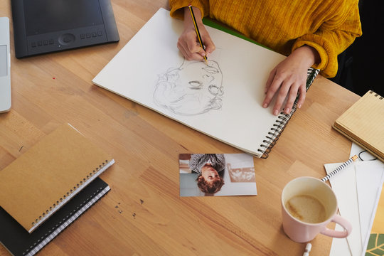 Woman at modern workspace drawing on paper