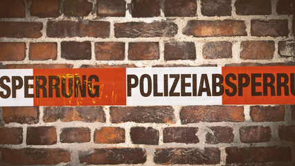 Polizei Absperrband vor Zielsteinwand