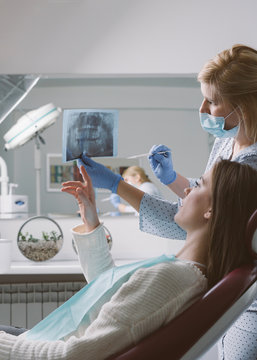 Young woman discussing her jaw x-ray with her dentist