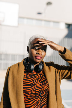 Black woman with headphones looking at camera