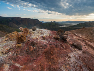 Colorful rhyolit red and orange fumarole at foot of Brennisteinsalda mountain with panorma of...