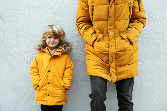 Father and kid wearing yellow hooded coat.