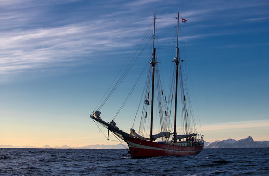 Sailboat in the sea in the morning sunlight over mountains background,