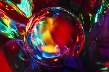 Abstract shot of glass ball on colorful holographic backdrop