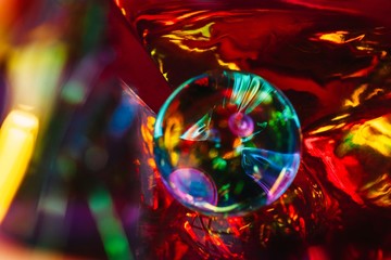 Abstract shot of glass ball on colorful holographic backdrop
