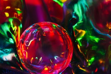 Abstract shot of glass ball on colorful holographic backdrop