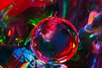 Abstract shot of glass ball on colorful holographic backdrop