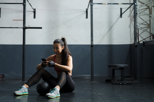 Young Woman Checking Her Phone At The Gym