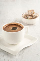 A cup of Turkish coffee and delight on a wooden table