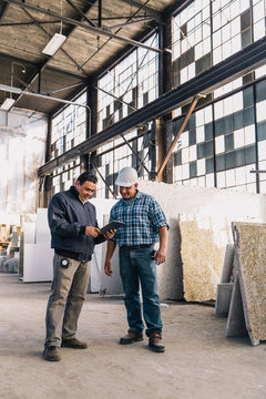Boss Consulting With Worker at Manufacturing Facility