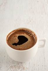 A cup of Turkish coffee on a wooden table