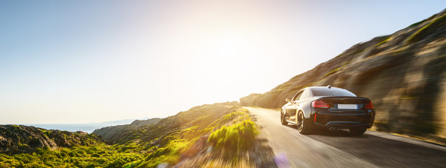 Fototapeta rental car in spain mountain landscape road at sunset obraz