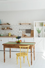 Light white kitchen in modern style with yellow wood chair and wood table