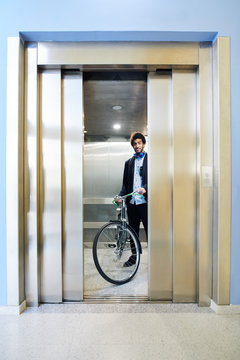 Man with bicycle in building elevator