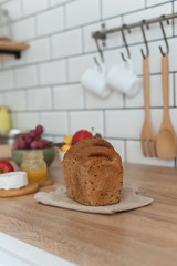  baked bread on napkin on the kitchen table, cheese and fruit, healthy breakfast