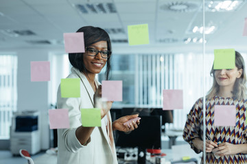 Businesspeople Looking at Glass Board