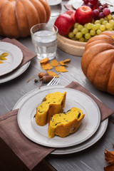 Pumpkin bread on plate, pumpkin and vegetables on a festive autumn table
