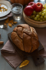 Bread, grapes in bowl and gray linen napkin on cutting board on the table